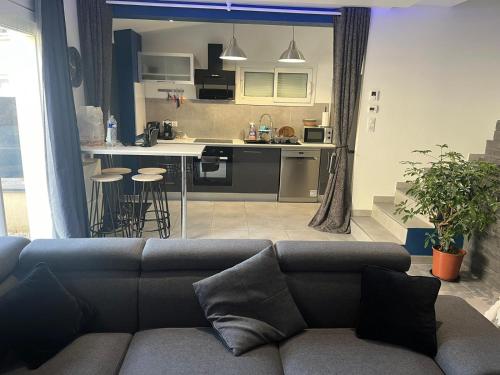 a living room with a couch and a kitchen at Villa chaleureuse Centre ville - Parking privée in Gap