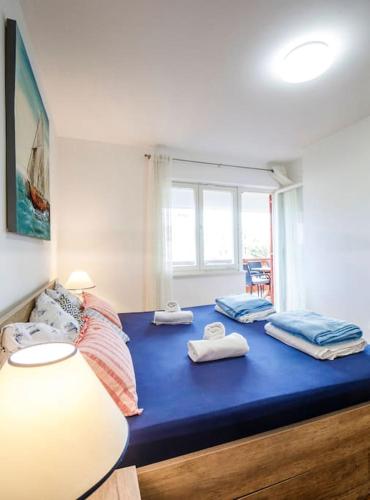 a room with a blue bed with towels on it at Apartment Tara in Njivice