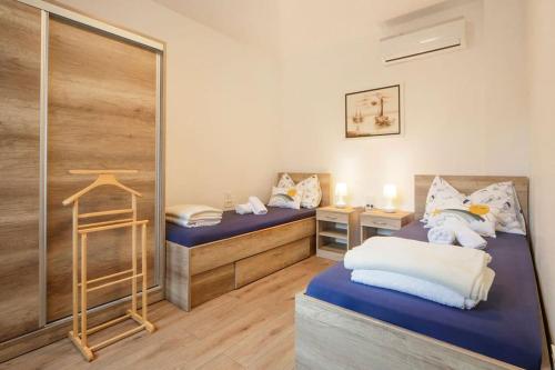 een slaapkamer met 2 aparte bedden en een spiegel bij Apartment Tara in Njivice