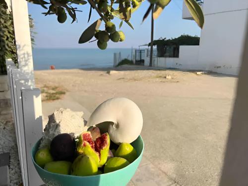 a bowl of fruit with a bird and strawberries at House by the sea suite 2 in Skála Foúrkas
