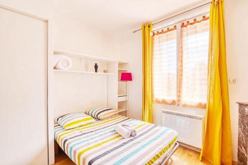 Cette petite chambre comprend un lit avec des rideaux jaunes. dans l'établissement T2 ds Villa-Terrasse-Clim-pkg-MEET- Zénith-Odyssud, à Toulouse