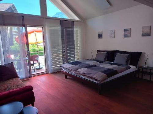 a bedroom with a bed and a couch in it at NEW.. Matten Central Family Suite, sleeps 4 in Matten