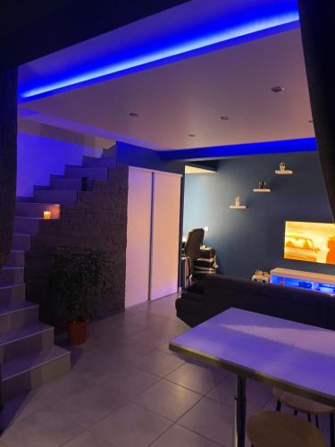 Villa chaleureuse Centre ville - Parking privée في غاب: غرفة بها درج مع أضواء أرجوانية