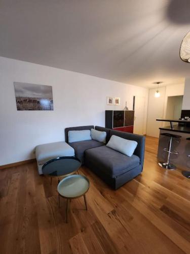 un salon avec un canapé bleu et deux tables dans l'établissement Bel appartement avec fibre et parking, à Massy