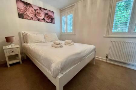 劍橋的住宿－Quaint 2 bed Cottage in the Heart of Cambridge，卧室配有白色床和毛巾