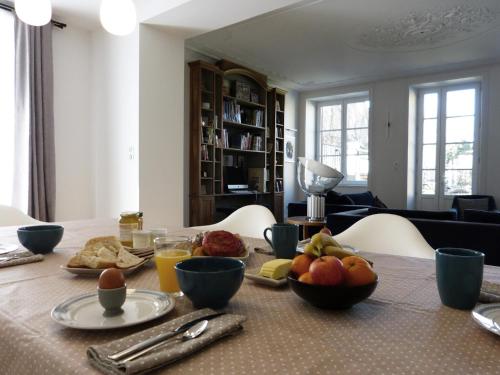 una mesa con un plato de fruta. en Chambres d'hôtes Les Pergolas, en Marcigny