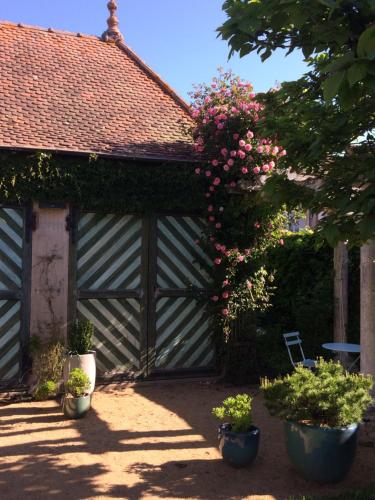 un garaje de madera con un ramo de flores en Chambres d'hôtes Les Pergolas, en Marcigny