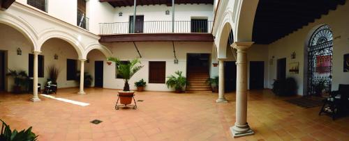 a courtyard of a building with pillars and plants at Apartamentos Fariñas 11 in Sanlúcar de Barrameda