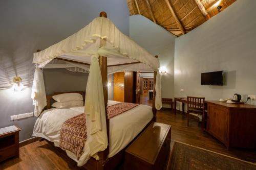 a bedroom with a canopy bed in a room at Emburara Farm Lodge in Mbarara