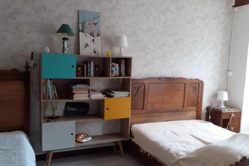 - une chambre avec un lit et une étagère avec des livres dans l'établissement Maison Familiale à la Montagne, à Soulom