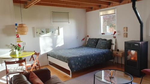 uma sala de estar com uma cama e uma mesa em B&B Houtstee em Veendam