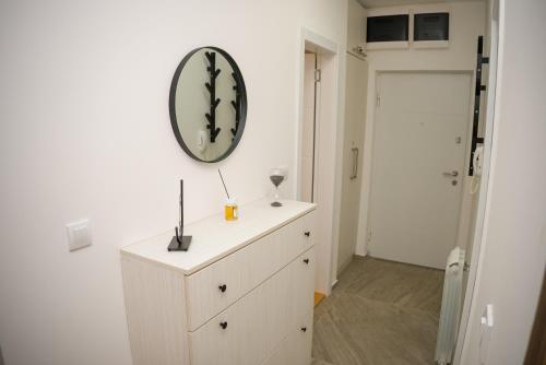 a white dresser with a mirror on a wall at Apartment Infinity in Kruševac