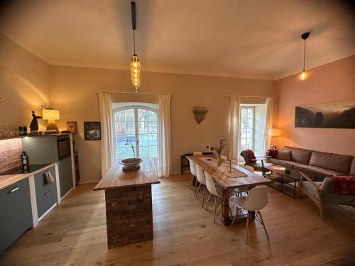 een keuken en een woonkamer met een tafel en een bank bij Alte Brennerei Schloss Zehista EG Rittersporn in Pirna