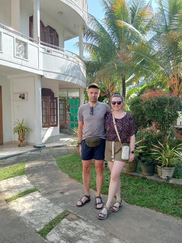 a man and a woman standing in front of a building at Power Zone Guest House in Matale