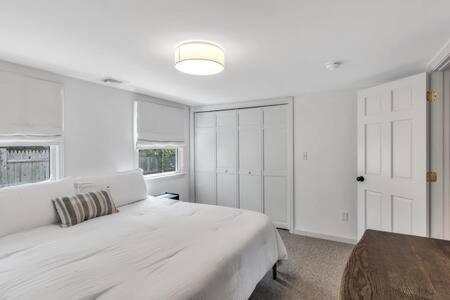 a white bedroom with a large bed and a window at Cape Cod Retreat with Beach Access in Falmouth
