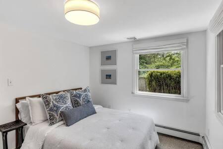 una camera da letto bianca con un letto e una finestra di Cape Cod Retreat with Beach Access a Falmouth