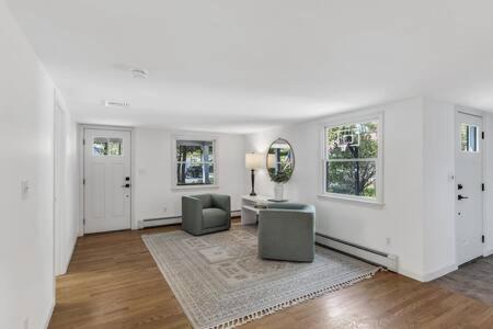 a living room with a table and chairs and a mirror at Cape Cod Retreat with Beach Access in Falmouth