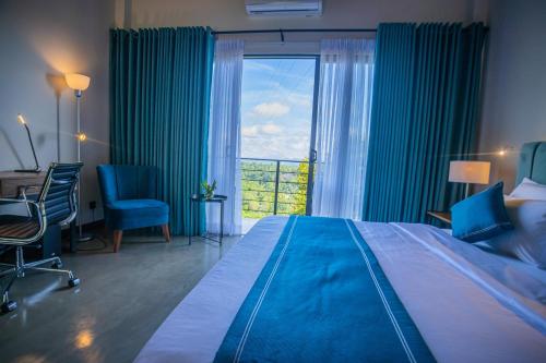 a bedroom with a large bed and a large window at Amore Resorts in Kobbekaduwa