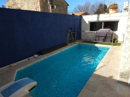 une petite piscine bleue à côté d'un mur bleu dans l'établissement Appart Piscine Privée 80M2 7mn vélodrome et Métro, à Marseille