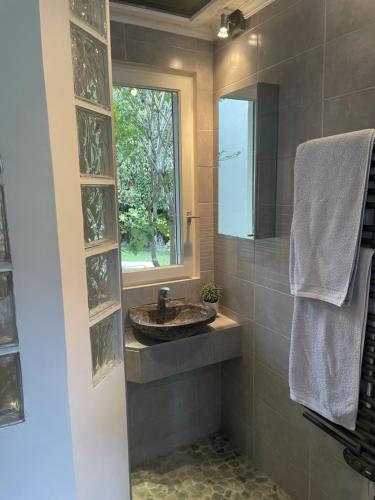 La salle de bains est pourvue d'un lavabo et d'une fenêtre. dans l'établissement Maison au calme proche Paris Arena, à Issy-les-Moulineaux