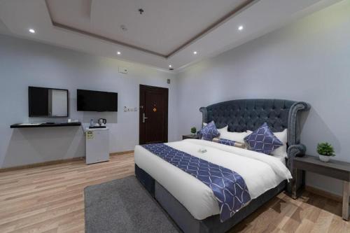 ein Schlafzimmer mit einem großen Bett und einem Flachbild-TV in der Unterkunft هوليداي بلس المروه- Holiday Plus Al Marwa in Dschidda