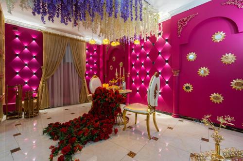 a pink room with a chandelier and red flowers at Shoxjahon Hotel - 600 Mbps Internet in Tashkent