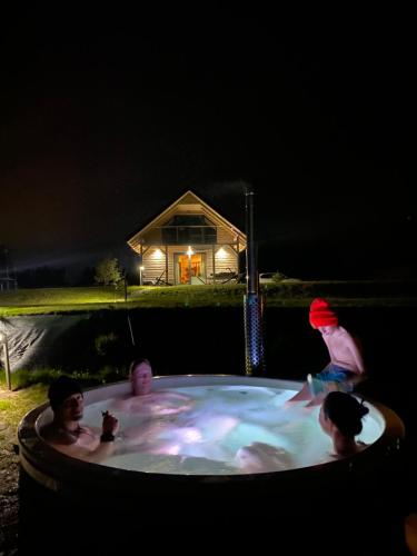 a group of people in a hot tub at night at Mazurski Domek - Wake Up Home Ogonki in Ogonki