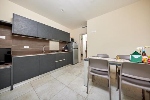 a kitchen with black cabinets and a table and chairs at CallaLillyJardin in Malcesine