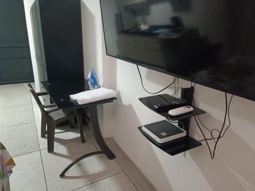 um monitor de computador pendurado numa parede com uma secretária em Apto 101 em Cúcuta
