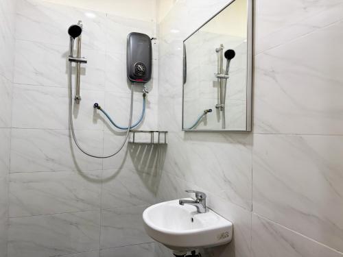 a bathroom with a sink and a phone on the wall at Inang Street Stay - Cheng Business Park in Melaka