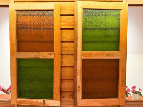 a wooden book shelf with two glass doors at Inang Street Stay - Cheng Business Park in Melaka