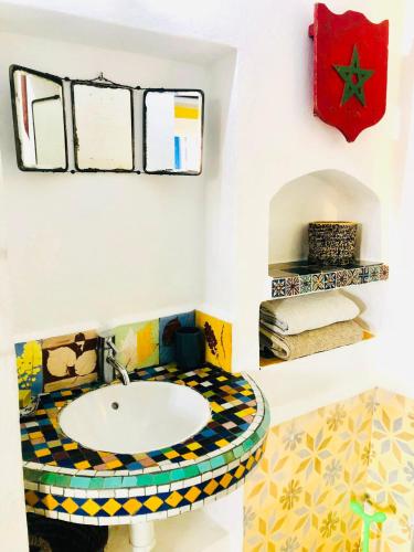 a bathroom with a sink and a mosaic floor at Dar 91 Essaouira in Essaouira