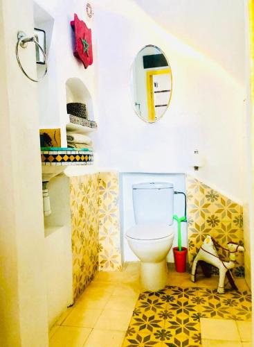 a bathroom with a toilet and a mirror at Dar 91 Essaouira in Essaouira