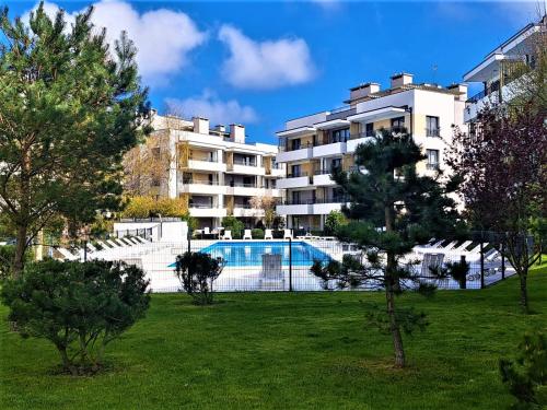 a large building with a swimming pool in a park at Apartament Deluxe in Ustronie Morskie