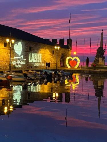 a building with hearts painted on it next to a body of water at LULLABY HOUSE LAZISE in Lazise