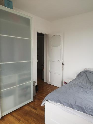 une chambre blanche avec un lit et un placard dans l'établissement Maud’s apppartment, à Asnières-sur-Seine