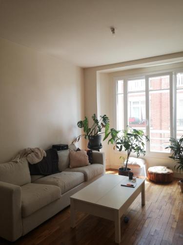 un salon avec un canapé et des plantes en pot dans l'établissement Maud’s apppartment, à Asnières-sur-Seine