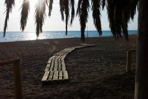 a wooden pathway on a beach with the ocean at Rex Hotel in Zakharo
