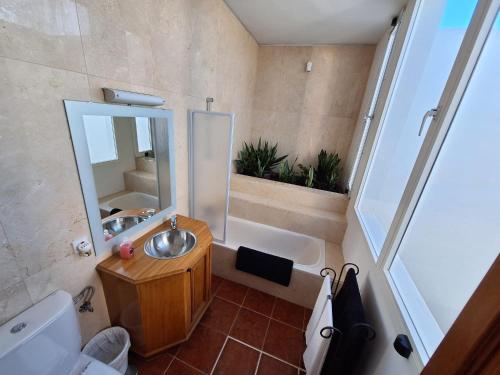 a bathroom with a tub and a sink and a mirror at CASA COSTA VOLCAN in Teguise