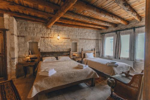 Un dormitorio con dos camas en una habitación con ventanas. en Zula Cave House, en Ürgüp