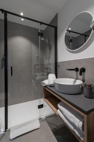 a bathroom with a sink and a glass shower at Hotel Pension Waldesruh in Bad Ischl