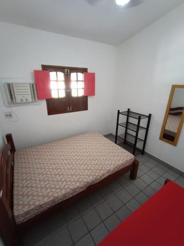 a bedroom with a bed and a window in a room at Onda Colorida - Praia de Serrambi (CASA 1 - ROSA) in Porto De Galinhas