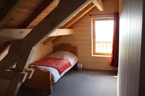 a bedroom with a bed in a wooden house at chalet montagne la lupina in Les Orres