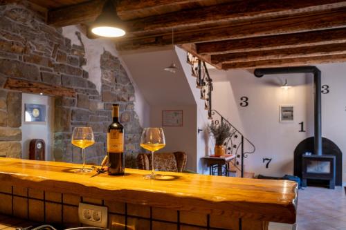 a bottle of wine and two glasses on a bar at Wine House Rakar in Gračišče