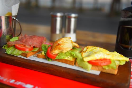 a plate of food with sandwiches on a table at Sanafir Hotel - El Pacha Suites Sharm - Adults Only in Sharm El Sheikh