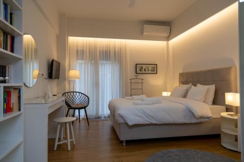 ein Schlafzimmer mit einem Bett und einem Schreibtisch mit einem Stuhl in der Unterkunft Comfort & Elegance in Kolonaki - 2BD Apt in Athen