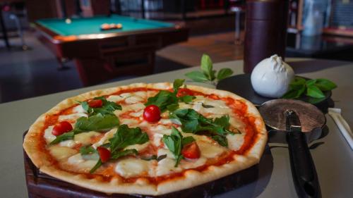 a pizza sitting on top of a table with a knife at Sanafir Hotel - El Pacha Suites Sharm - Adults Only in Sharm El Sheikh