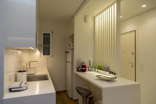 eine Küche mit einer weißen Theke und einem Waschbecken in der Unterkunft Comfort & Elegance in Kolonaki - 2BD Apt in Athen