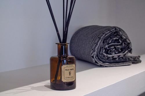 a bottle of wine sitting on a shelf next to a towel at Pine House - Faro Airport, Beach and City Center in Faro