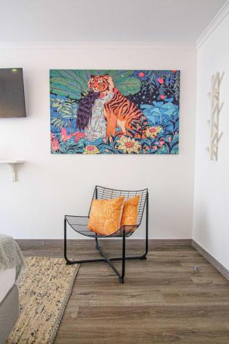 a bench in a room with a painting on the wall at Pine House - Faro Airport, Beach and City Center in Faro